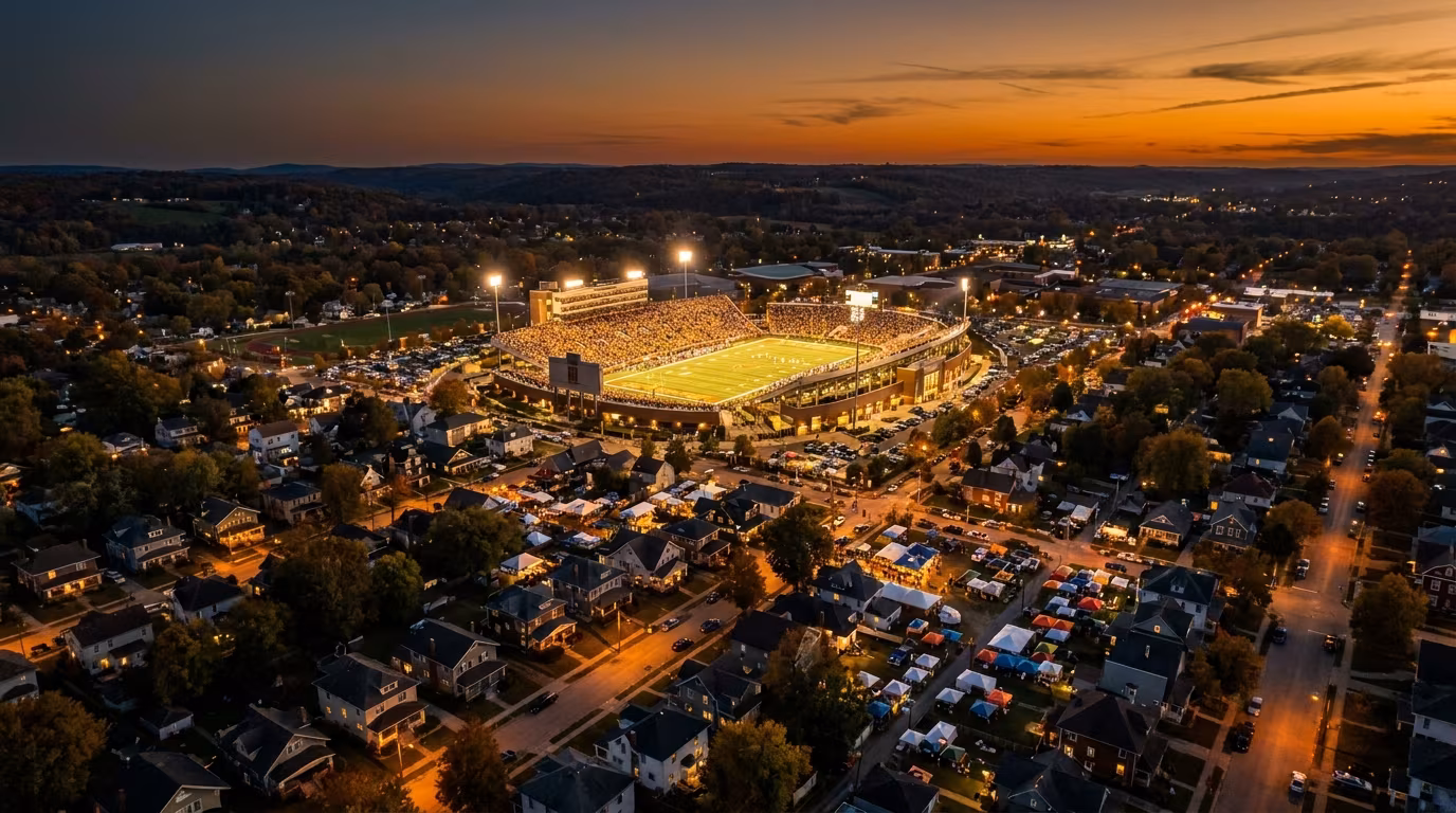 College football stadium at dusk in a college town Airbnb market on game day